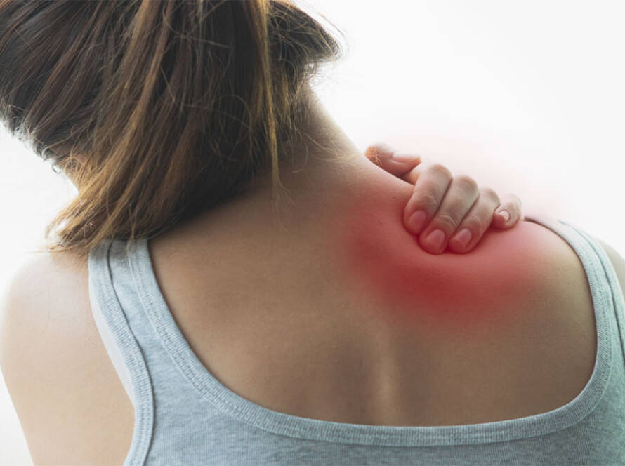 Woman’s back with red spot to signify muscle pain, her hand on her shoulder.